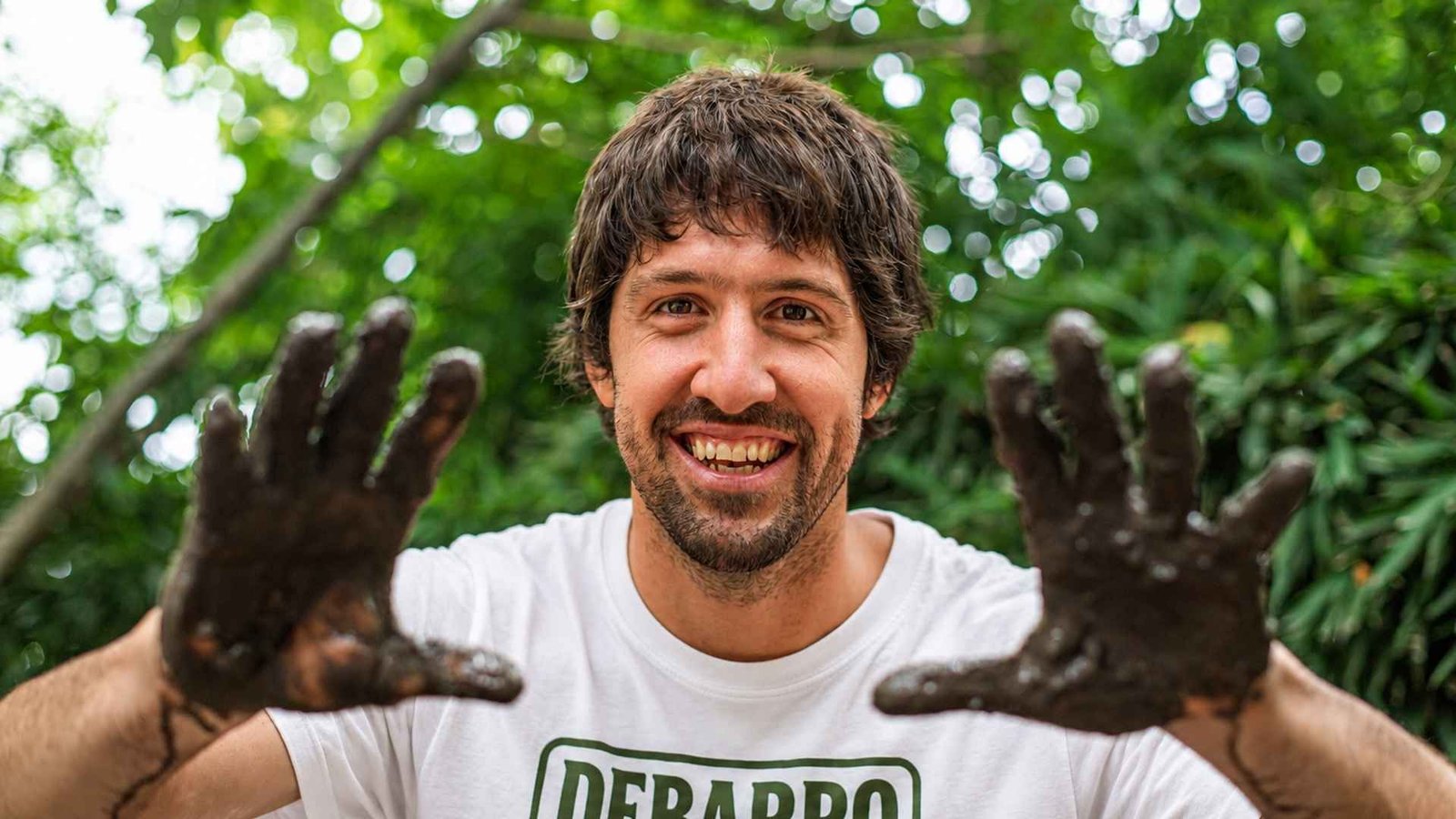 Chalo Parma con las manos embarradas frente a la vegetación